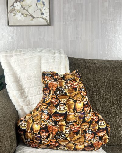 Hand painted pot of gold throw pillow sitting on sofa with white blanket