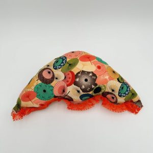 Umbrella shaped orange throw pillow with colorful umbrellas on fabric.