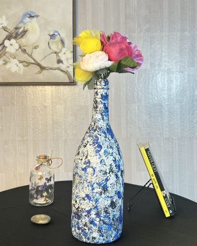Hand painted blue and white vase with black streaks with bouquet inside.