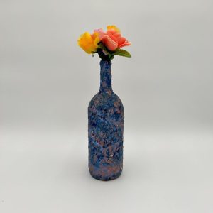 Hand painted blue swirl vase with yellow and peach flowers inside.