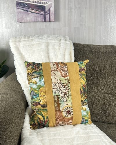 Handmade brown jungle pillow sitting sofa and white throw