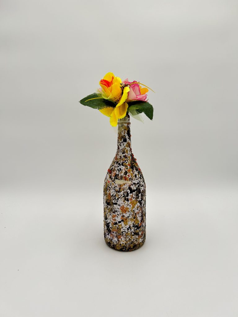 Multicolor vase with brown, orange and gray shades, with flowers placed inside.