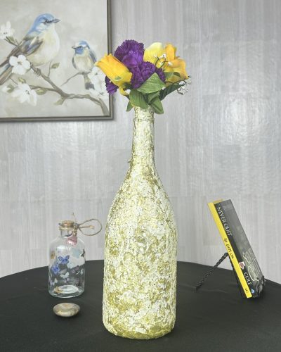 Hand painted lime green vase with flowers inside on table