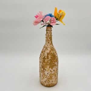 Hand painted gold decorative glass vase with pink flowers inside.