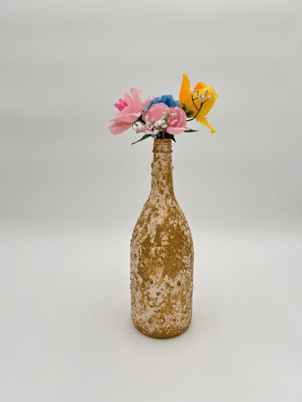 Hand painted gold decorative glass vase with pink flowers inside.