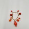 Orange beaded bracelet laying on all white surface