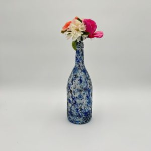 Royal blue unique glass vase with dashes of white and black, with pink and white flowers.