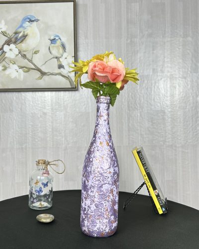 Hand painted purple vase with gold streaks and a flower bouquet inside