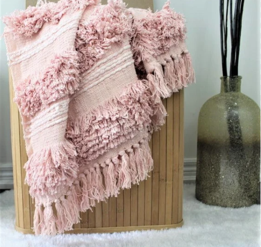 Beautiful pink handmade blank throw sitting on bench in living room