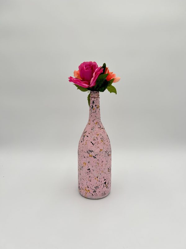 Blush pink decorative glass vase with hot pink flower inside.