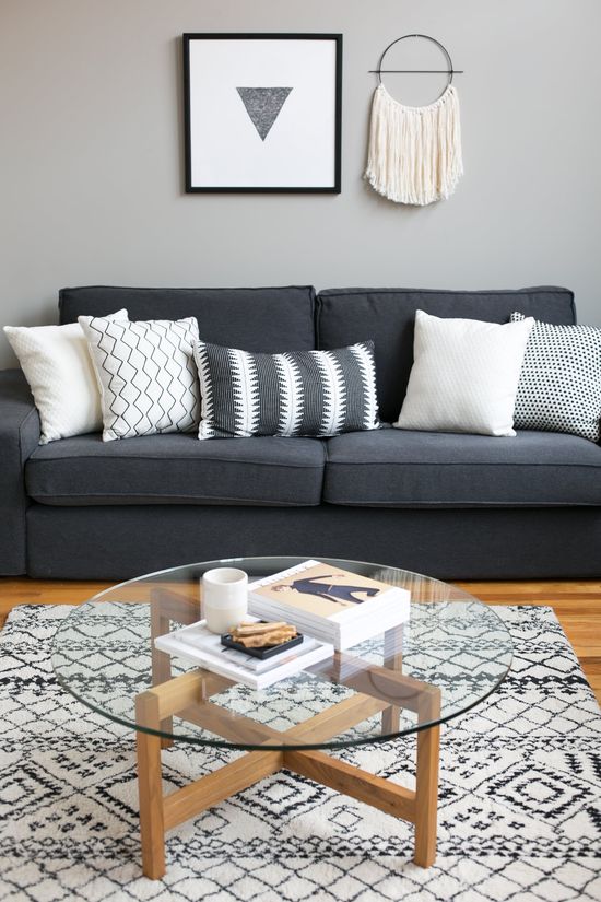 Dark gray sofa with neutral tone decorative throw pillows on it