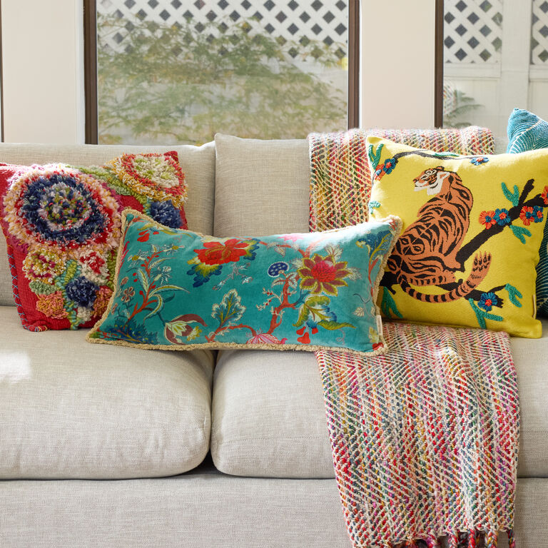 Multi-color throw pillow set of 3 sitting on white couch