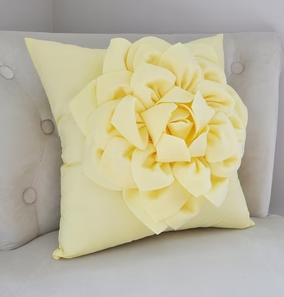 Yellow decorative throw pillow with large flower in center 