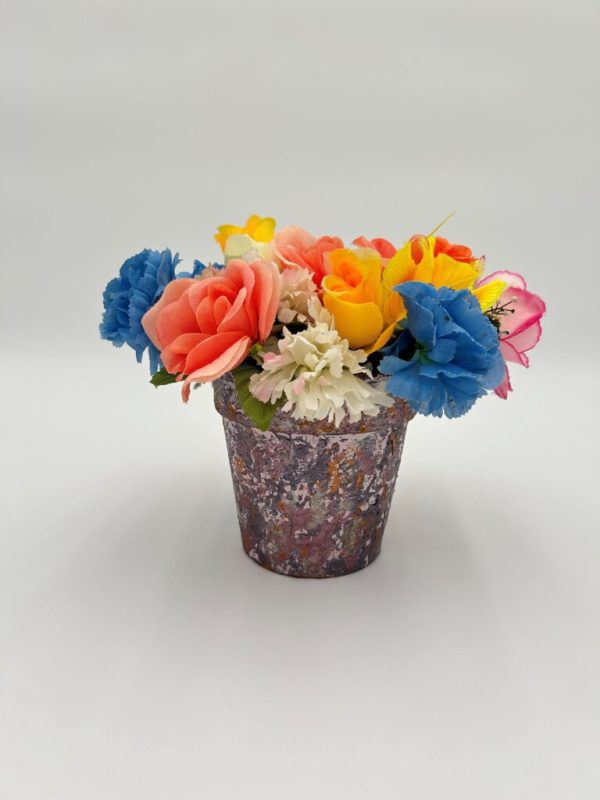 Pink hand painted decorative flower pot with colorful flowers inside for summer decorating