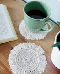 White handmade cloth coaster with green cup sitting on it.