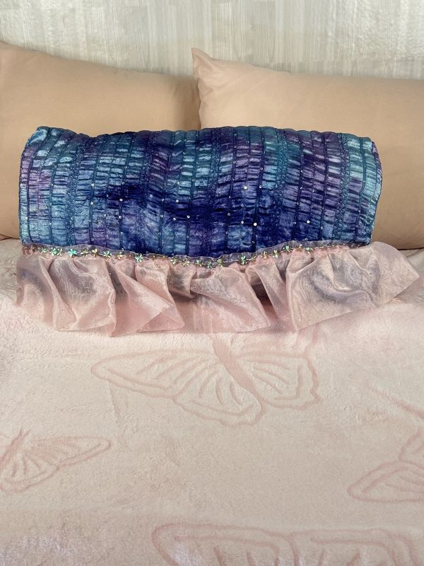 Beautiful blue, purple and pink pillow sitting on pink bed for bedroom dopamine decorating