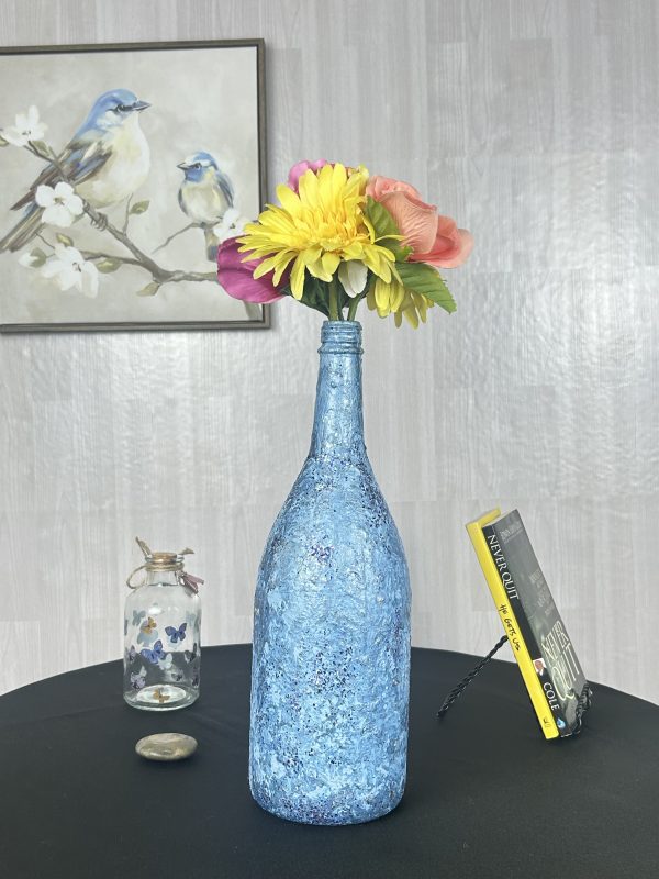 Hand painted bright blue vase with colorful flowers inside