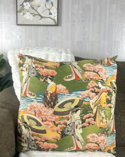 Large oriental green throw pillow sitting on brown sofa