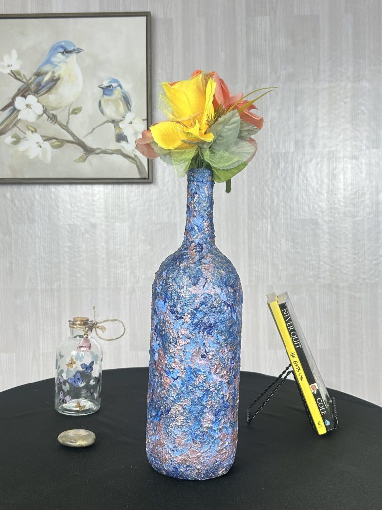 Hand painted blue and purple swirl vase sitting on table with black table cloth
